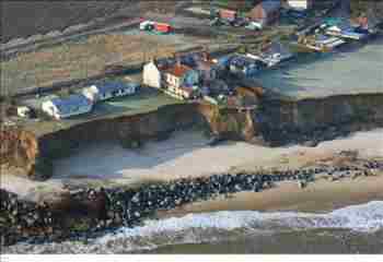 aerial photograph showing receding cliffs threatening nearby houses